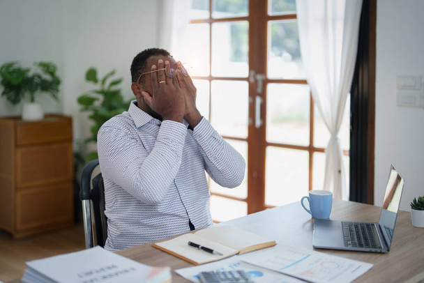 Burnout American African business man in stress works with many paperwork document, migraine attack, Freelance, work from home. - Fotografie, Obrázek