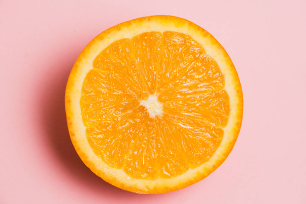 Juicy orange half macro on a pink background. Delicious fruit on a bright background - Foto, afbeelding