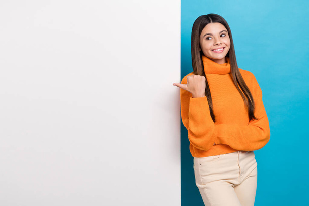 Photo of positive funny girl long hairstyle knit turtleneck hold arms crossed look directing empty space isolated on blue color background. - Foto, Bild