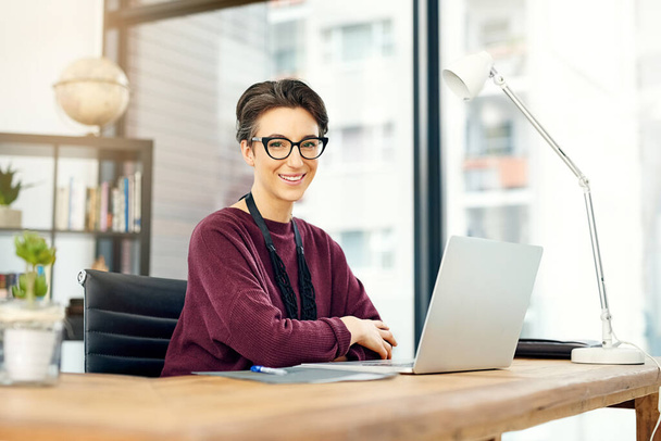 Estoy ascendiendo constantemente al éxito. Retrato de una joven empresaria que trabaja en una laptop en una oficina moderna - Foto, imagen