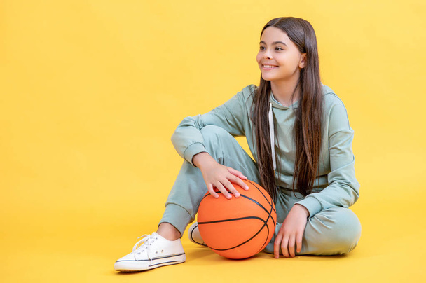 teen basketball girl isolated on yellow, banner. teen basketball girl in studio. teen basketball girl on background. photo of teen basketball girl with ball. - Фото, зображення