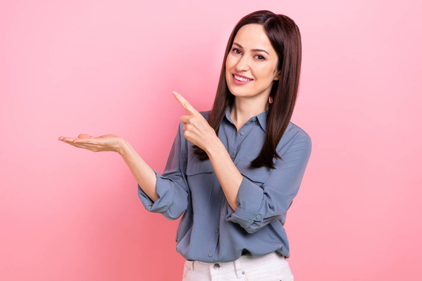 Photo of cheerful lovely lady wear stylish grey clothes arm presenting empty space low prices offer isolated on pink color background. - Foto, Bild