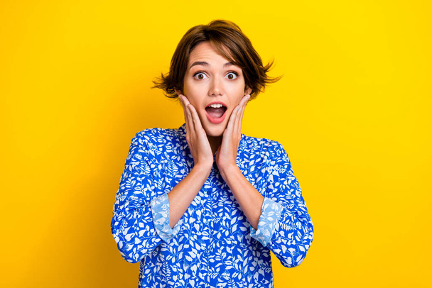 Photo of charming excited lady wear print shirt arms cheeks open mouth isolated yellow color background. - Valokuva, kuva