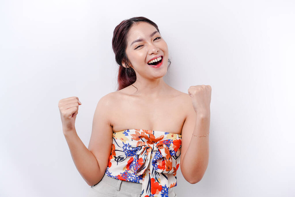 A young Asian woman with a happy successful expression wearing floral top isolated by white background - Photo, Image