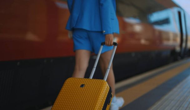 Mujer camina por la plataforma en la estación de tren. - Foto, imagen