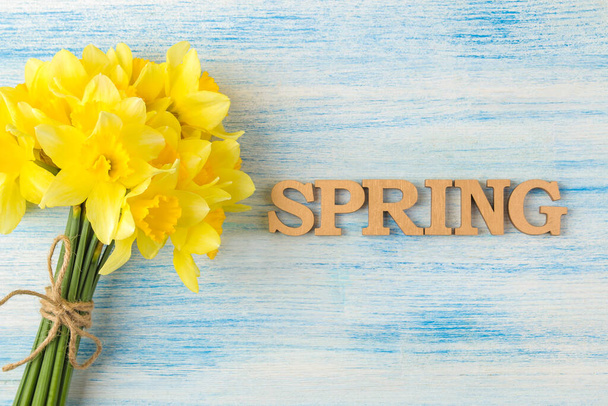 Boeket narcissen, lentebloemen op een blauwe achtergrond. zicht van bovenaf. - Foto, afbeelding