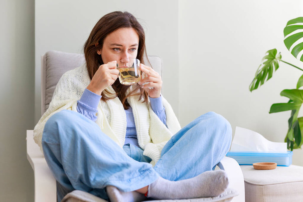 Young woman feeling sick drinking herbal te - Foto, immagini