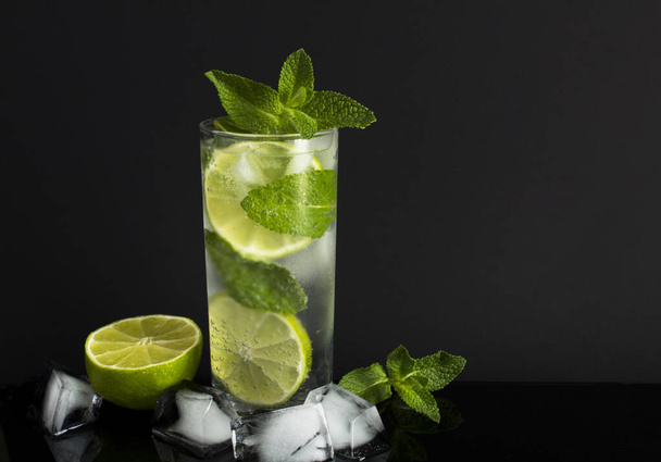 Mojito-Cocktail im Trinkglas auf schwarzem Hintergrund. Nahaufnahme. - Foto, Bild
