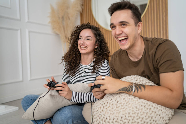 Two people couple man and woman boyfriend and girlfriend husband and wife or friends play console video games hold joystick controller happy smile emotional gesture reaction family leisure copy space - Foto, Imagem