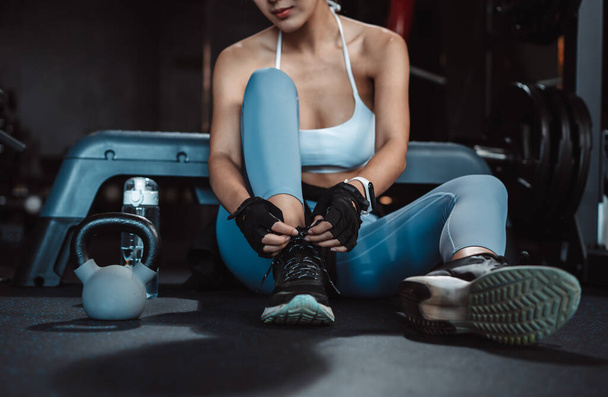 Woman exercise workout in gym fitness breaking relax after training sport with kettlebell, dumbbells and water bottle healthy lifestyle bodybuilding. - 写真・画像