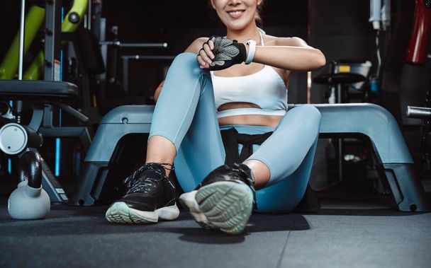 Woman exercise workout in gym fitness breaking relax after training sport with kettlebell, dumbbells and water bottle healthy lifestyle bodybuilding. - Fotografie, Obrázek