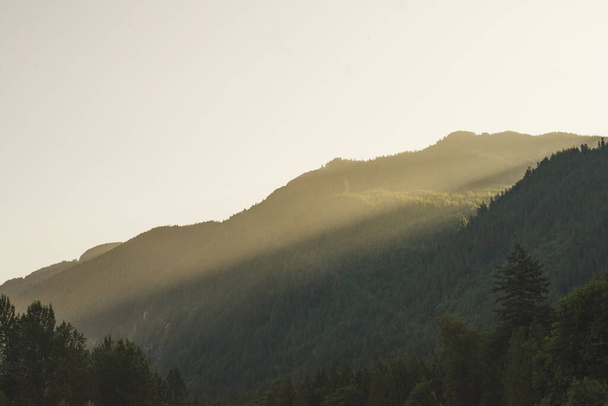 Berglandschaft mit Nebel und Sonnenstrahlen am Morgen in British Columbia, Kanada. - Foto, Bild