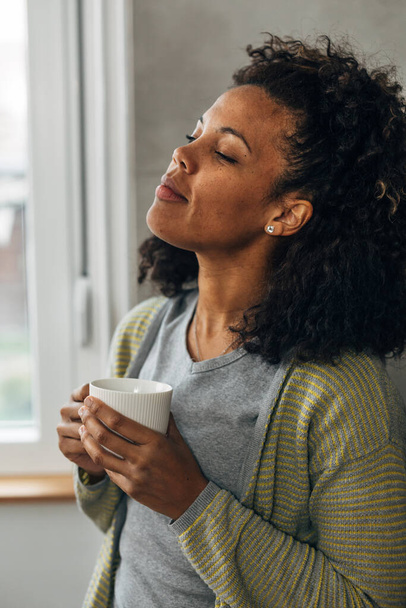 Middle aged woman is enjoying her morning coffee alone - Φωτογραφία, εικόνα