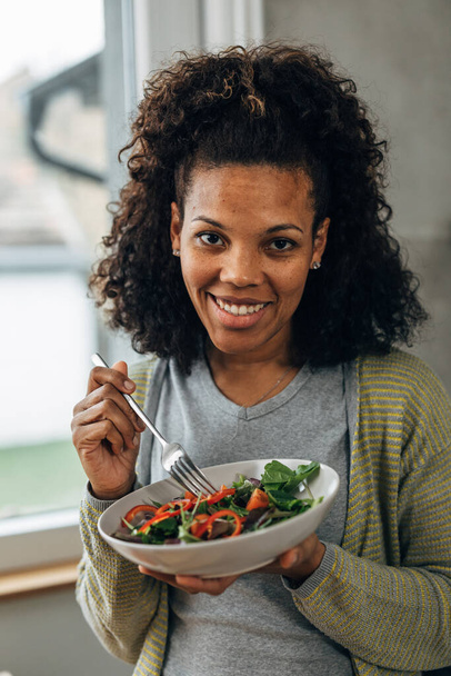 Happy vegan woman is eating a salad for lunch - Foto, imagen