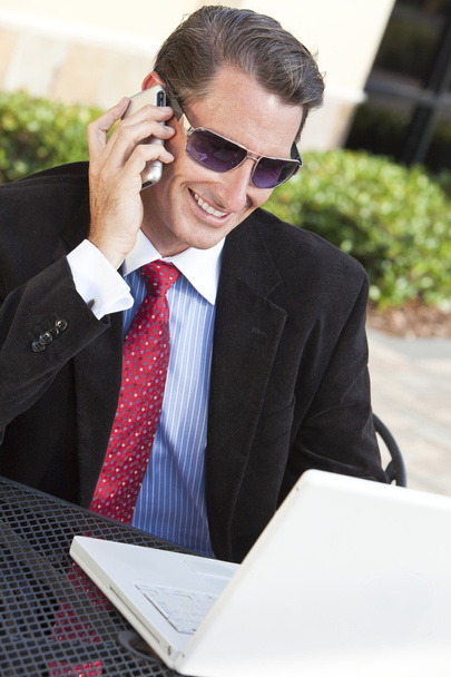 Businessman In Sunglasses Using Laptop Computer and Cell phone - Valokuva, kuva