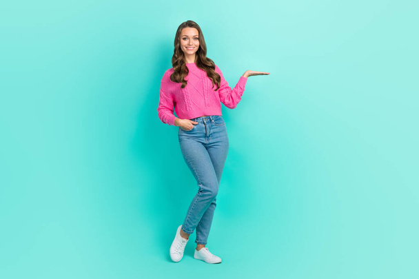 Full length photo of pretty shiny girl wear pink sweater holding arm empty space isolated turquoise color background. - Фото, зображення