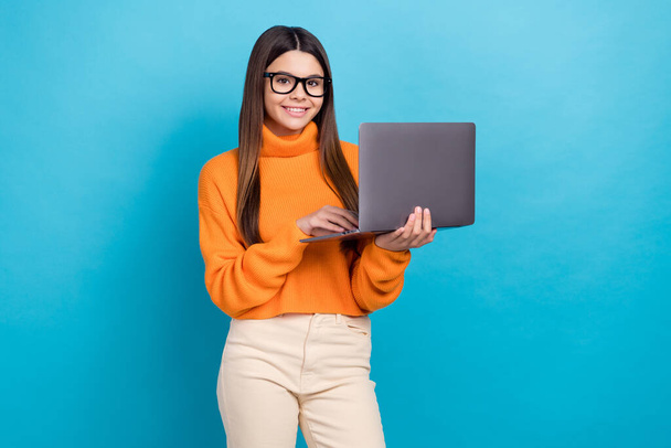 Photo of cheerful positive nice girl long hairstyle wear knit turtleneck in glasses holding laptop isolated on blue color background. - Photo, image