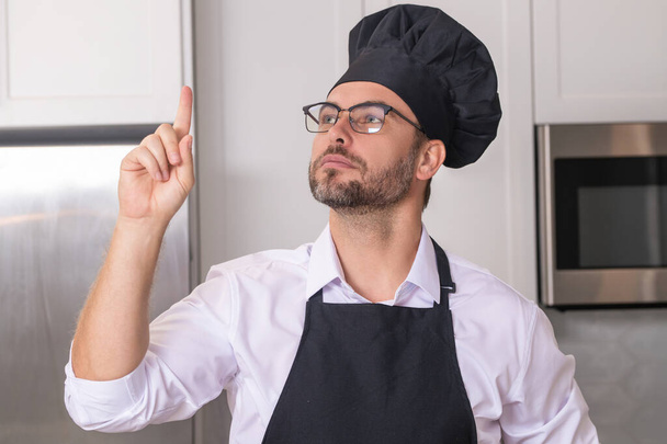 Idea for food. Restaurant menu concept. Hispanic man in baker uniform. Cooking and culinary. Male chef in working uniform, black apron, chef hat - Foto, Bild