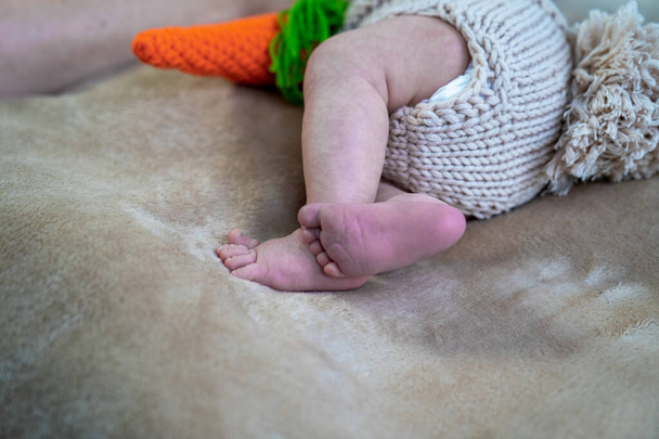 close up of tiny little baby feet on the sofa, infant pediatrician, child legs in knitted cloth diaper  - Photo, Image