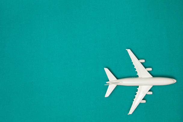 Airplane model. White plane on green background. Travel vacation concept. Summer background. Flat lay, top view, copy space. - Foto, imagen