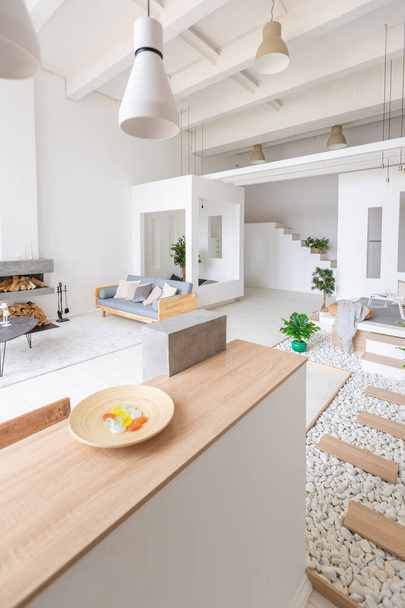 Luxury fashionable modern design studio apartment with a free layout in a minimal style. very bright huge spacious room with white walls and wooden elements. - Zdjęcie, obraz