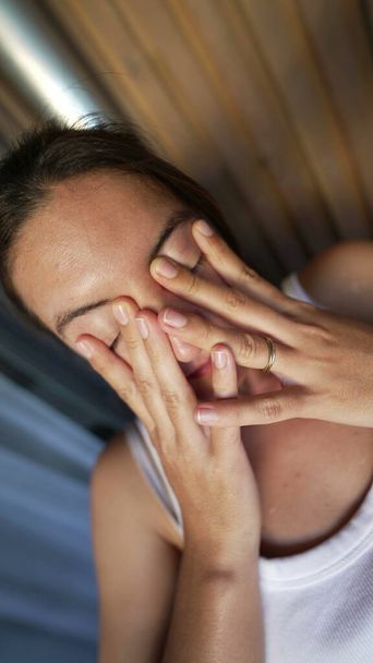 Стрессовая женщина, прикрывающая лицо, чувствует давление. Один встревоженный человек, страдающий от тревоги в трудные времена в вертикальном видео - Фото, изображение