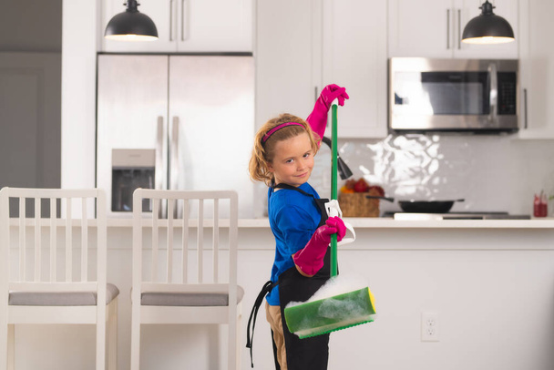 Portret dziecka sprzątanie, rozwój koncepcji, rozwój, relacje rodzinne. Koncepcja sprzątania i sprzątania domu. Dziecko używać odkurzacza i rękawice do czyszczenia. Home kuchnia tło - Zdjęcie, obraz