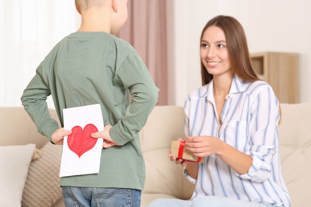 Little boy presenting gift to his mother at home - Foto, Bild