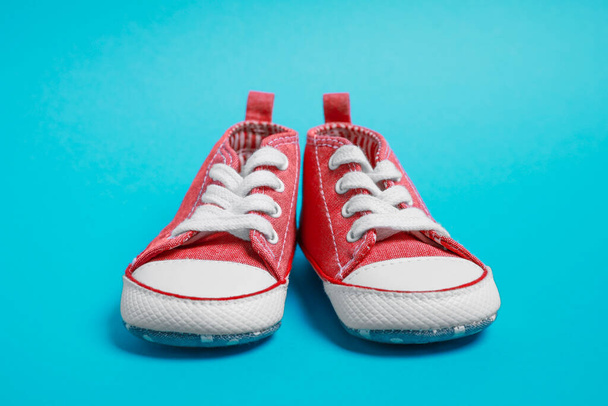 Pair of cute baby shoes on light blue background - 写真・画像