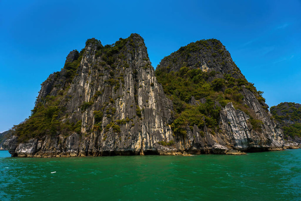 Scenic view of rock island in HaLong Bay, Vietnam, Southeast Asia. UNESCO World Heritage Site. Mountain islands at Ha Long Bay. Beautiful landscape Popular asian landmark famous destination of Vietnam - Photo, Image