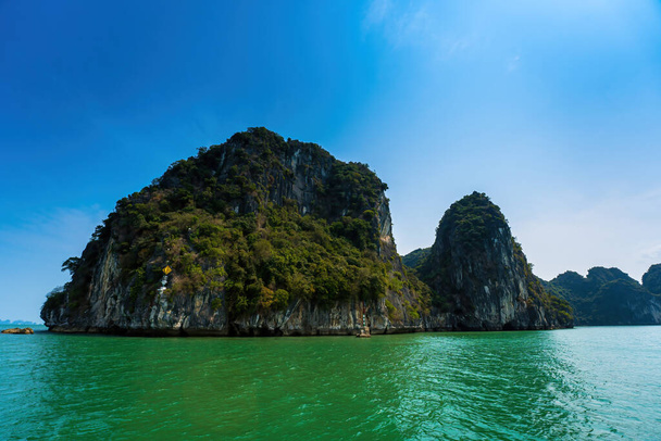 Scenic view of rock island in HaLong Bay, Vietnam, Southeast Asia. UNESCO World Heritage Site. Mountain islands at Ha Long Bay. Beautiful landscape Popular asian landmark famous destination of Vietnam - Valokuva, kuva