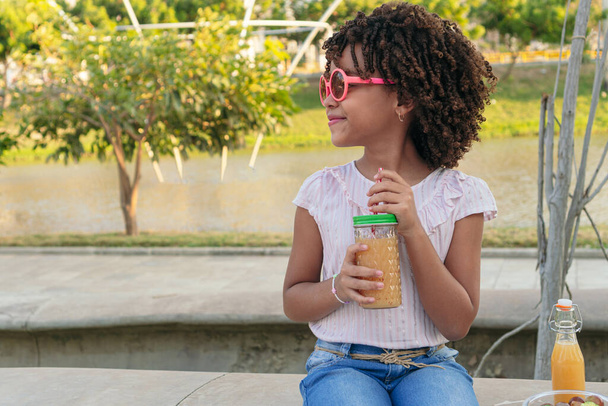 Mädchen im Park mit einem Glas gesundem Saft - Foto, Bild