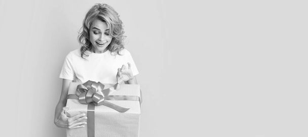 curieuse femme rousse heureuse boîte cadeau ouverte. anniversaire. Beauté femme isolé visage portrait, bannière avec maquette espace de copie - Photo, image