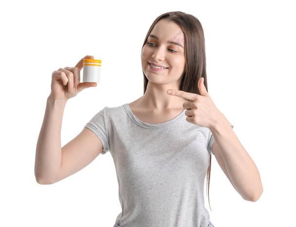 Jeune femme avec bouteille de suppléments vitaminiques sur fond blanc - Photo, image
