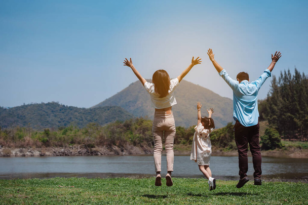 Happy family in the nature travel. family on weekend playing together in the meadow with river Parents hold the child and daughter hands.health life insurance plan concept. - 写真・画像