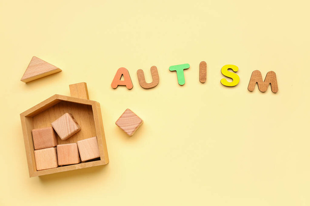 Word AUTISM with baby toys on beige background - Photo, Image