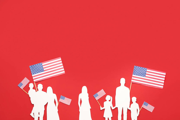 Семейные фигуры с флагами США на красном фоне. Праздник памяти - Фото, изображение