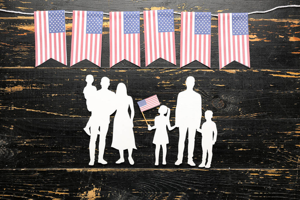 Family figures with USA flags on dark wooden background. Memorial Day celebration - Foto, imagen