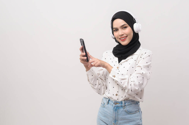 Young beautifu musliml woman wearing headset on white background - Фото, зображення