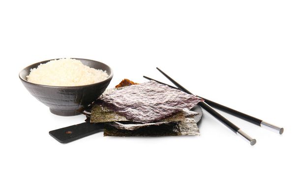 Tavola con fogli nori naturali, bacchette e ciotola di riso isolata su fondo bianco - Foto, immagini