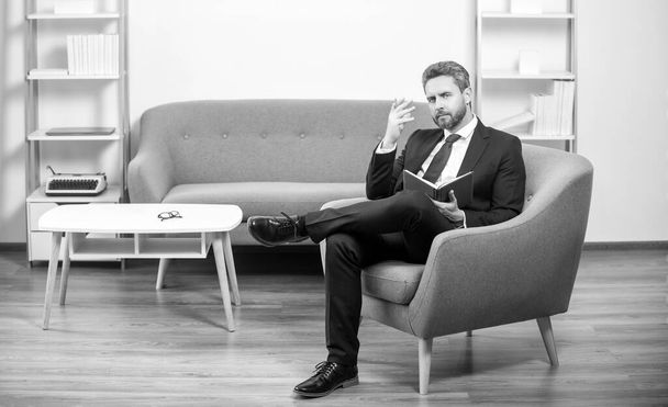 mature businessman in suit sit in office taking notes in notebook. - Fotoğraf, Görsel