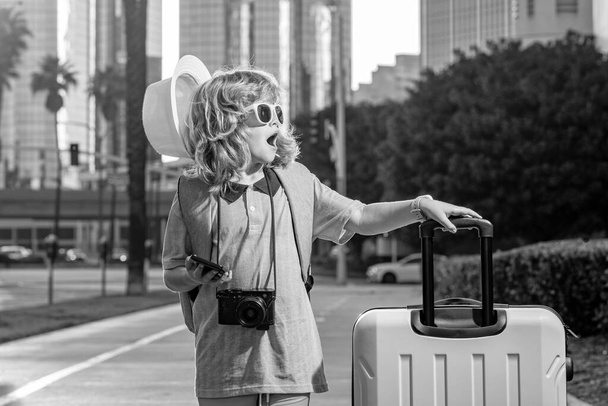 Matkailija turisti poika poika 7-8 vuotta vanha. Matkustaja matkustaa ulkomaille viikonloppuisin lomalle. Itsenäinen lapsi poika iso matka laukku - Valokuva, kuva