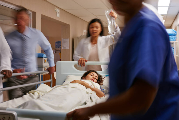 Sono corso in terapia intensiva. una squadra medica che fa scorrere una barella attraverso un corridoio ospedaliero - Foto, immagini