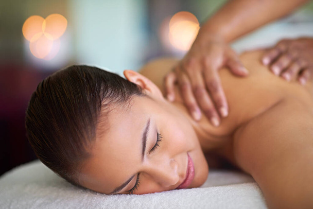 È tutto ciò che un corpo può chiedere. una giovane donna che si gode un massaggio alla schiena in una spa - Foto, immagini