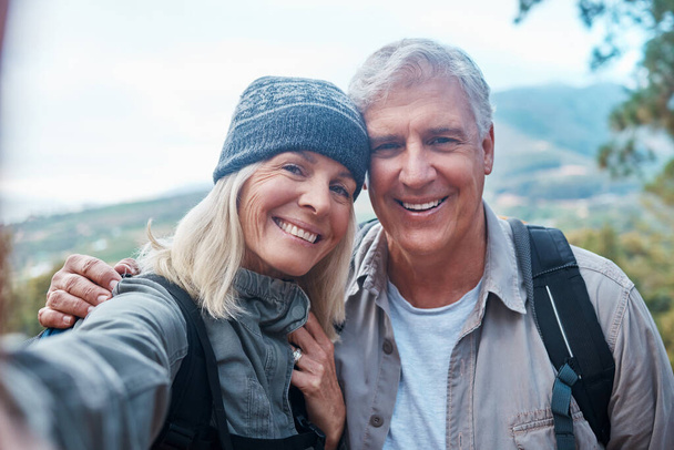Old couple, selfie and portrait, hiking in forest and happy people in nature and memory for social media post. Smile in picture, adventure and fitness, man and woman with active lifestyle and outdoor. - Valokuva, kuva
