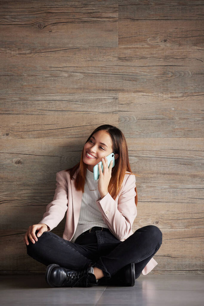 Young business woman, floor and phone call with smile for networking, discussion and talk in modern office. Professional female, smartphone and listen for conversation, chat and space for mock up. - Foto, Imagen