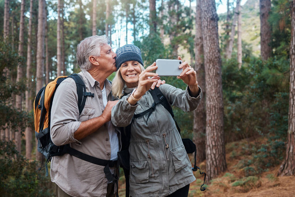 Vanhukset, pari ottaa selfie ja vaellus metsässä, onnellisia ihmisiä luonnossa ja muistissa sosiaalisen median postitse. Hymyile kuvassa, seikkailu ja kunto, vanha mies ja nainen ovat ulkona aktiivisella elämäntavalla. - Valokuva, kuva