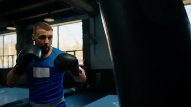 Boxe ginásio um boxeador treina seus socos batendo saco de perfuração - Filmagem, Vídeo