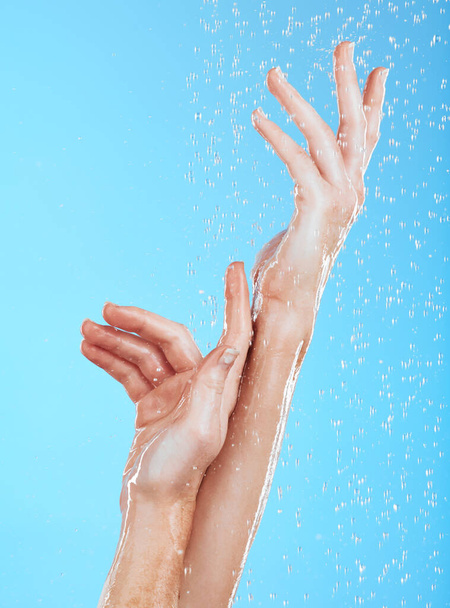 青い背景、スタジオの背景、または持続可能性のスキンケアに閉じられた女性、水滴や手を洗う。肌の健康のシャワー、クリーニングと美しさのための女性モデル、手と液体. - 写真・画像