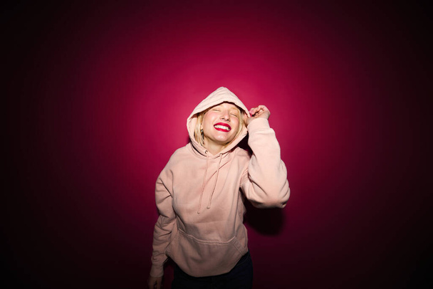 Portrait of a happy girl laughing and posing isolated on magenta background. Viva magenta, color of the year. - 写真・画像